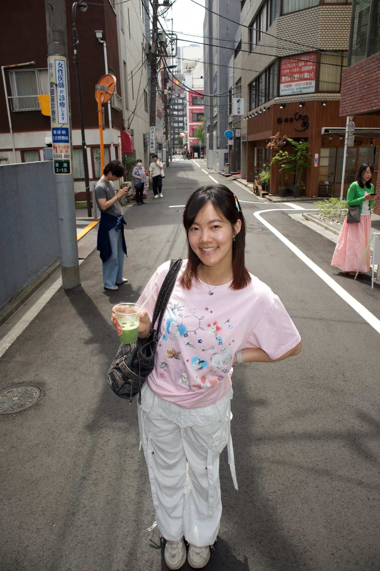 Esther holding an iced matcha on a Tokyo side street
